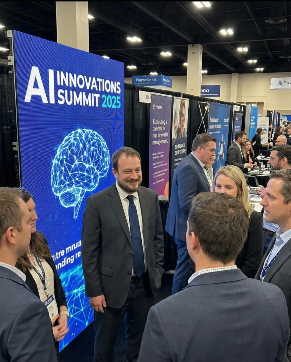 Alex Lamy talking with attendees at an AI conference